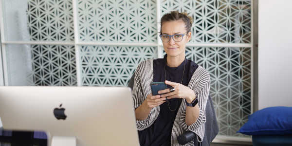 Clue's co-founder and chairwoman, Ida Tin, at her desk with a mobile phone and computer.