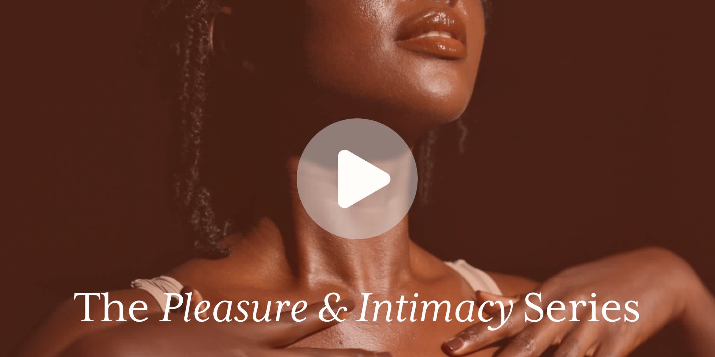 Close-up of a woman with glowing skin touching her collarbone. A play button is overlaid in the center. Text reads: “The Pleasure & Intimacy Series."