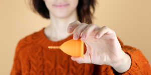 a woman holding a menstrual cup