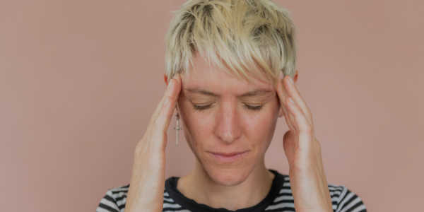 photo of a stressed woman holding her head