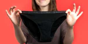 Photo of a woman holding up a pair of Modi Bodi period underwear