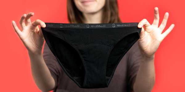 Photo of a woman holding up a pair of Modi Bodi period underwear