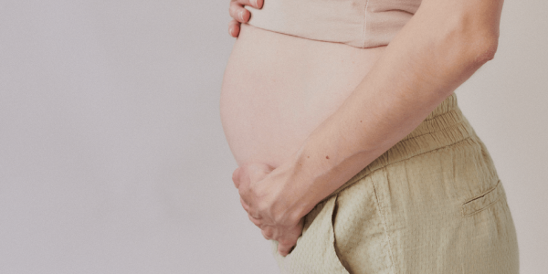 Imagem de uma pessoa grávida com as mãos na barriga