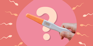 Hand holding a pregnancy test in front of a question mark, surrounded by swimming sperm
