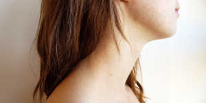 Side profile of a person's neck, from shoulder to base of the ear. 