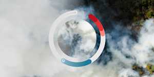 Aerial view of a forest area covered in thick smoke, overlaid with a circular data visualization showing progress or metrics in blue and red segments
