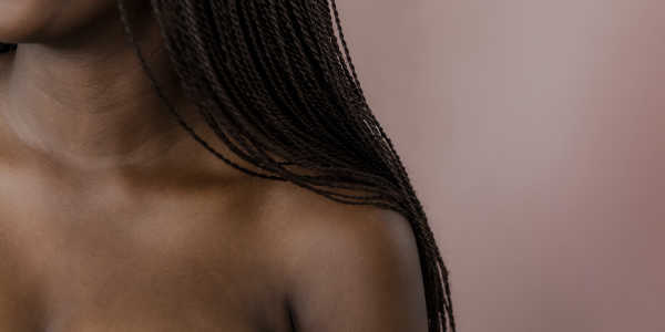 Ein Foto einer schwarzen Frau, die die Schulter, den Hals und die Haare zeigt