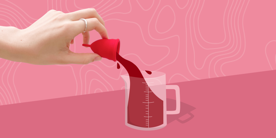 Hand holding a menstrual cup that's pouring blood into a measuring cup