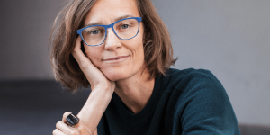 Portrait of Ida Tin wearing blue glasses and an Oura ring.