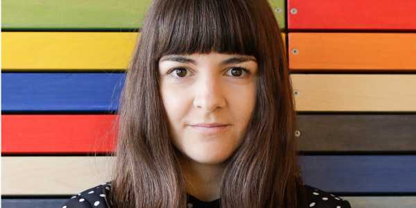 portrait of marija in front of colorful wood panels in the clue office in berlin