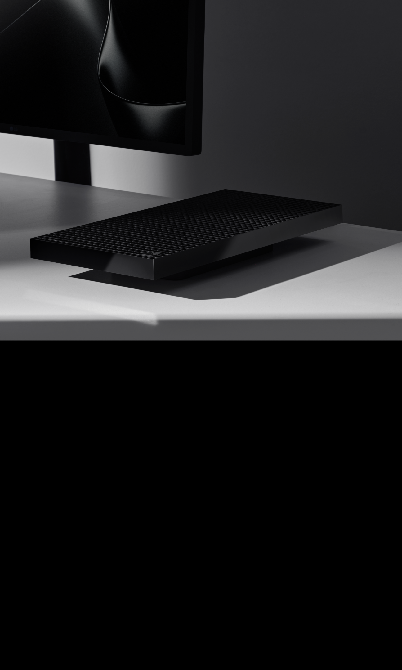 Black vented device on desk beside monitor