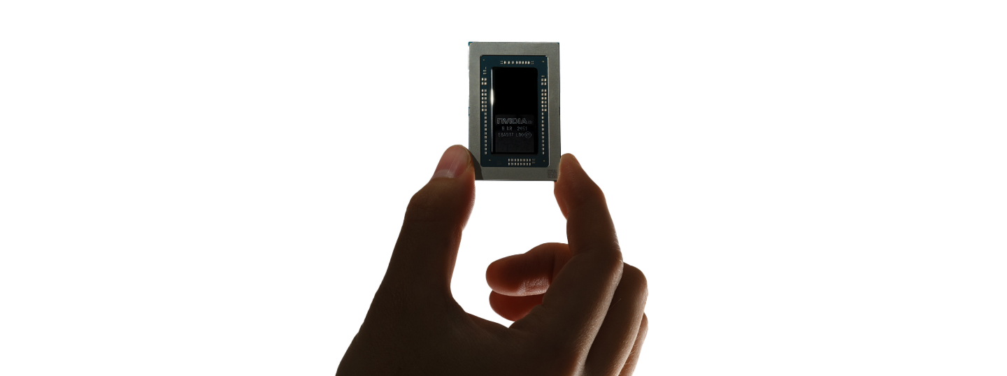 Side profile of a thin black device with a flat rectangular top and raised central base on a light background