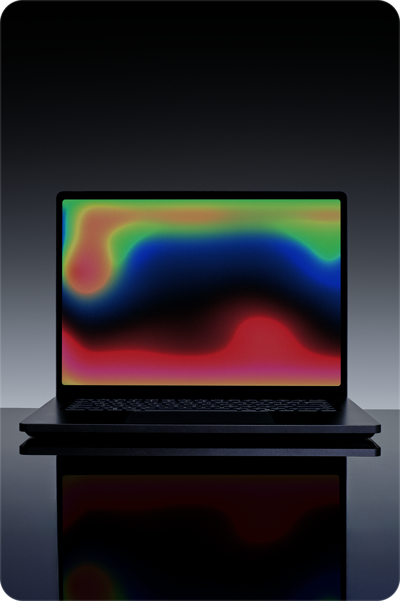 Ordinateur portable noir sur une surface réfléchissante avec un motif multicolore abstrait brillant à l’écran sur un arrière-plan gris