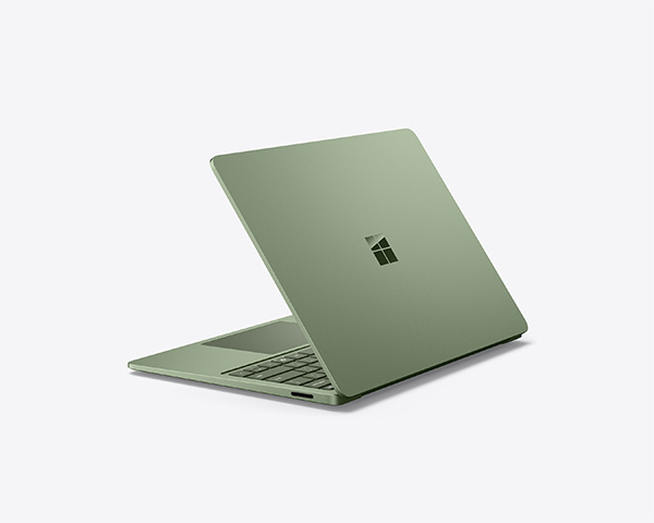 Jade Surface laptop partially open on a light background.
