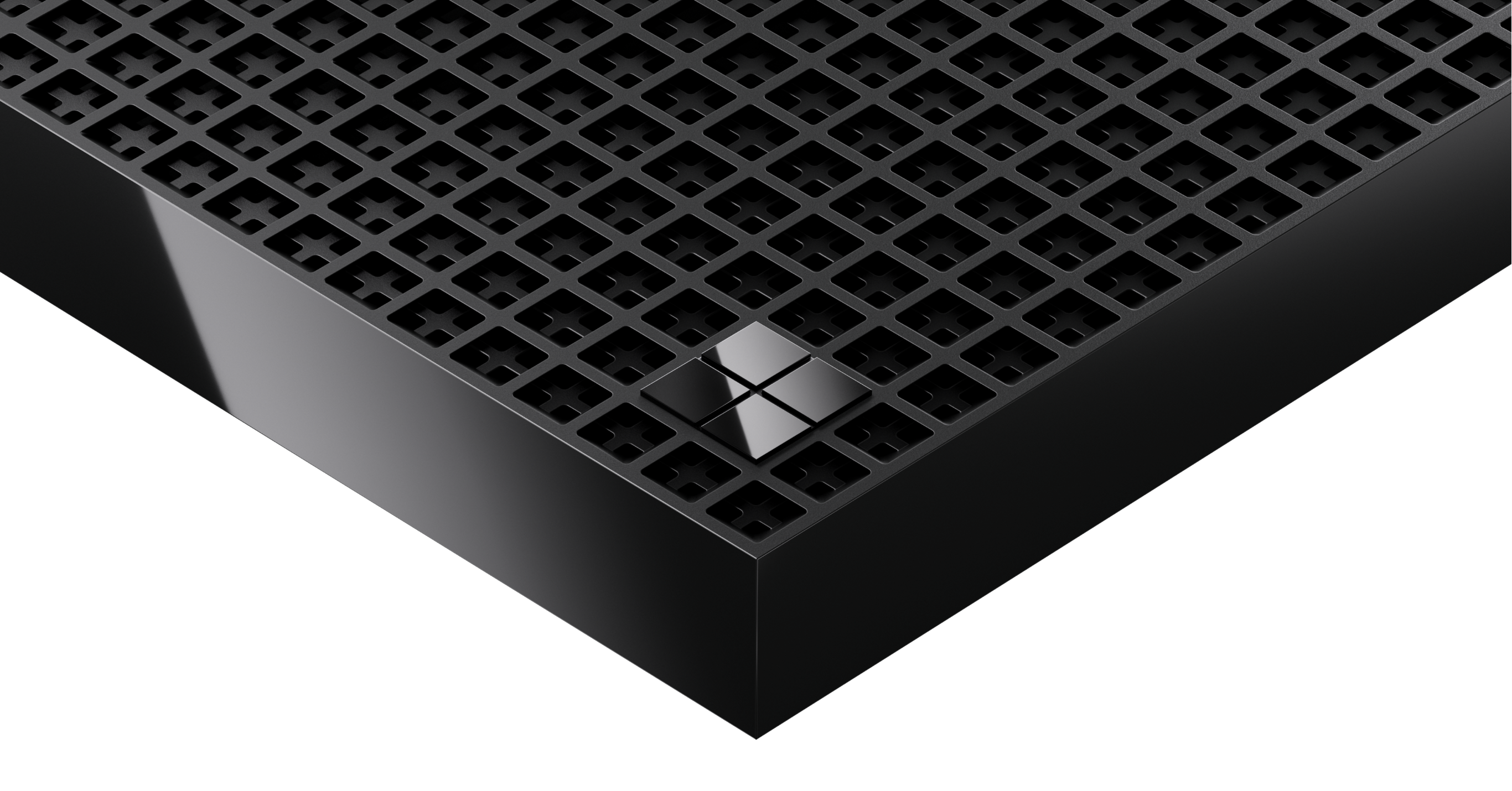 Close-up of black device corner with perforated grid surface and reflective Microsoft logo