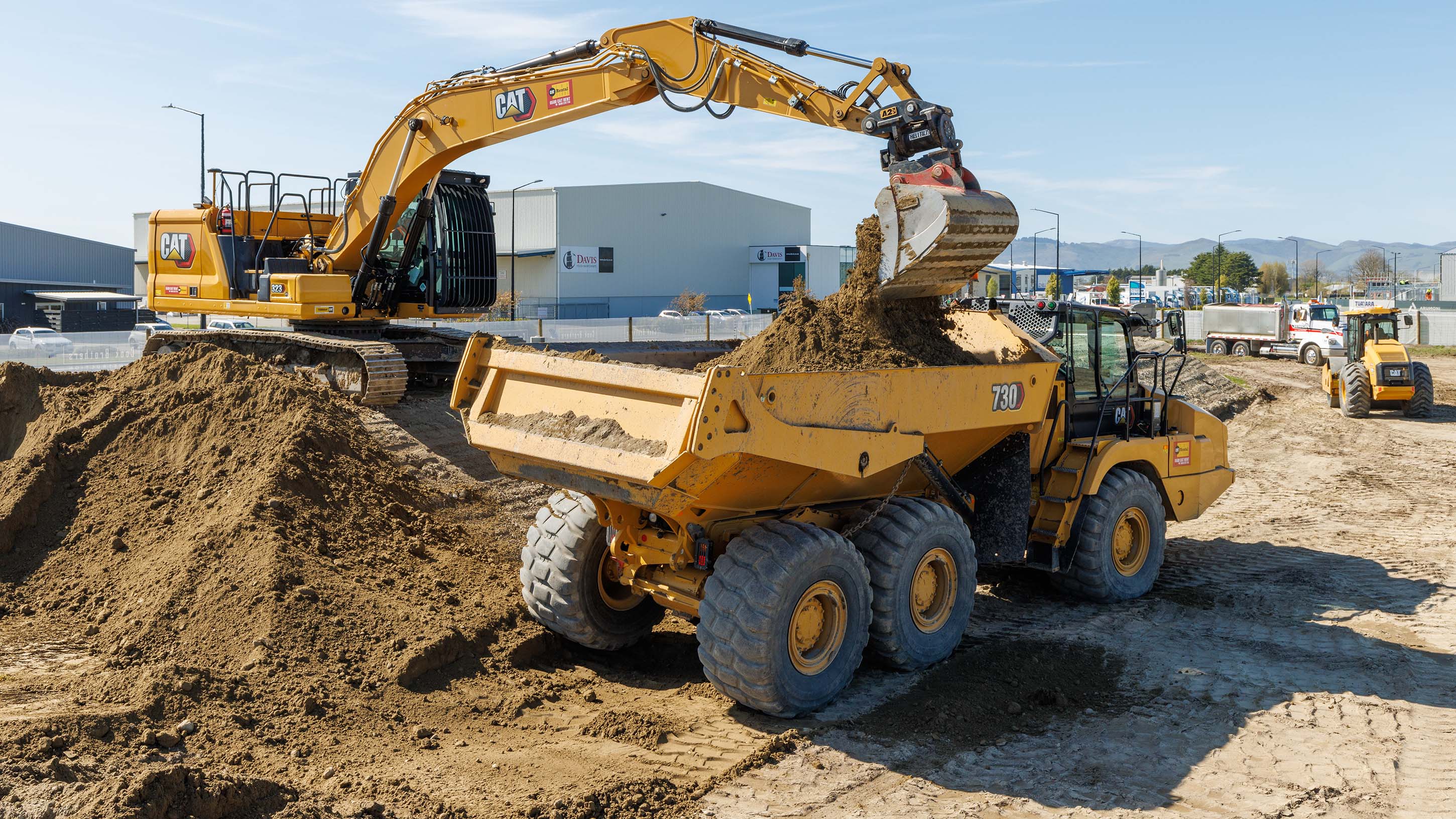 Cat Rental 323 excavator loading 730 articulated truck