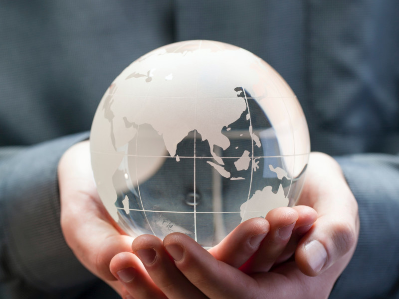 Image of hands holding a semi-transparent glass globe model