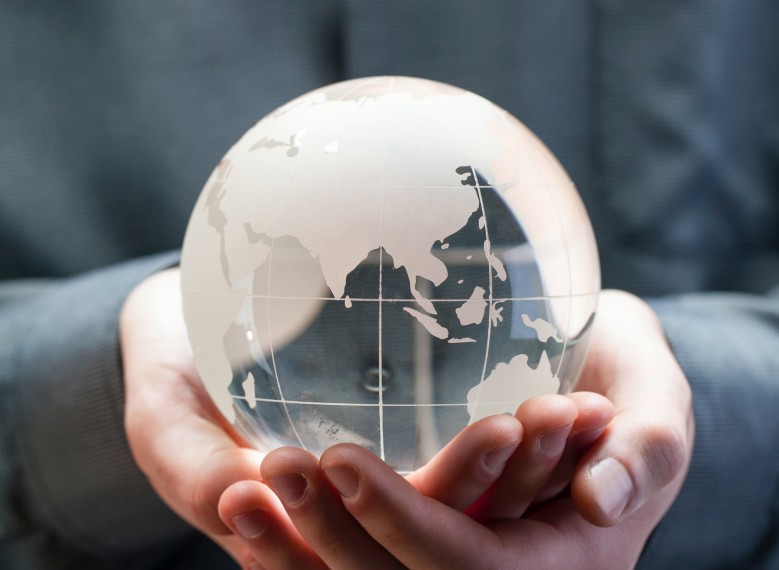 Image of hands holding a semi-transparent glass globe model