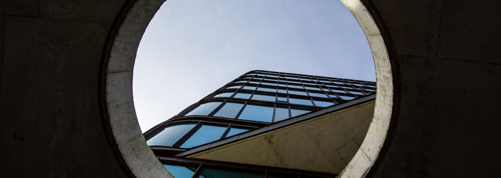 Image of a view towards the top of a building through a circular aperture 