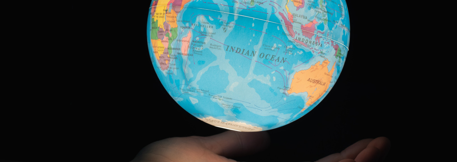 An image of a hand holding an illuminated globe