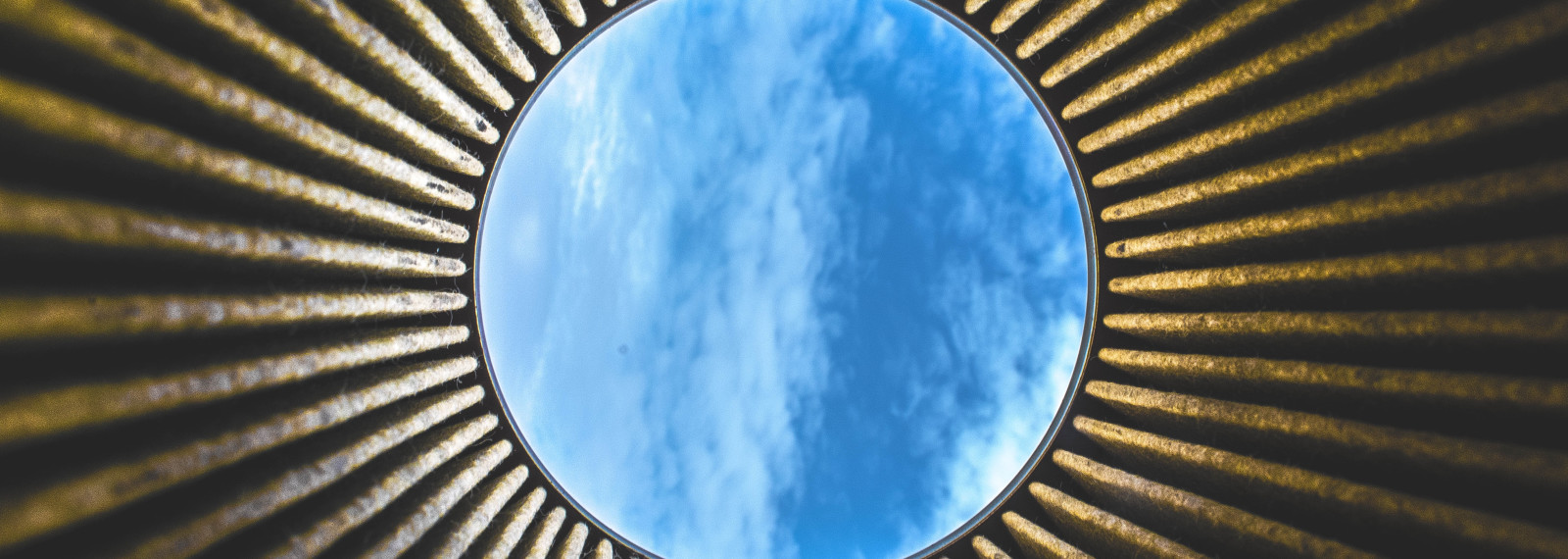 Looking up to the open sky through a circular building 