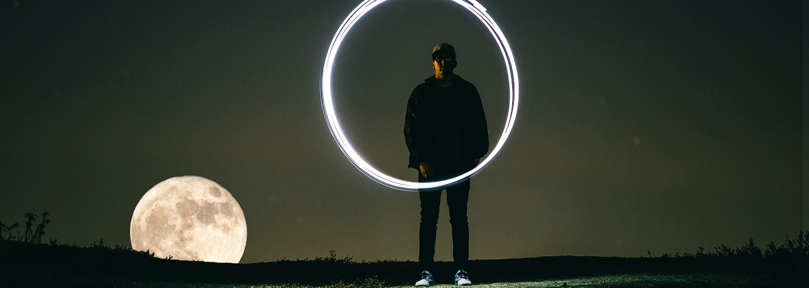 man standing behind an illuminated circle