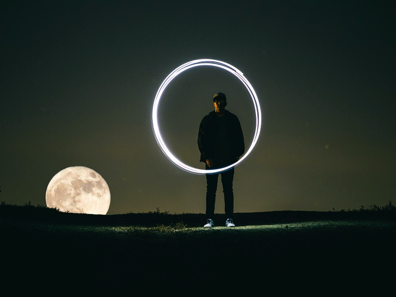 man standing behind an illuminated circle