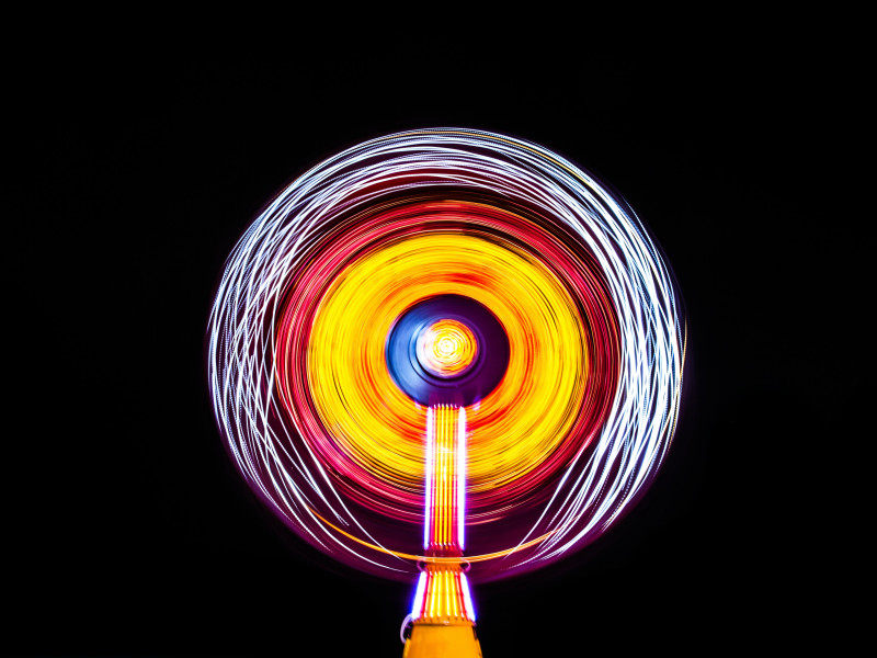 Image of circular light image emitted by a Ferris wheel in the night sky