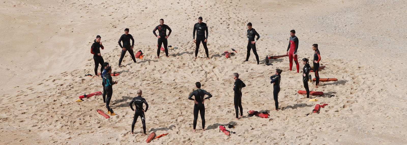 Image of a circle of people standing on a beach