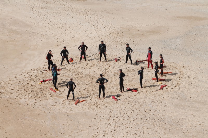 Image of a circle of people standing on a beach