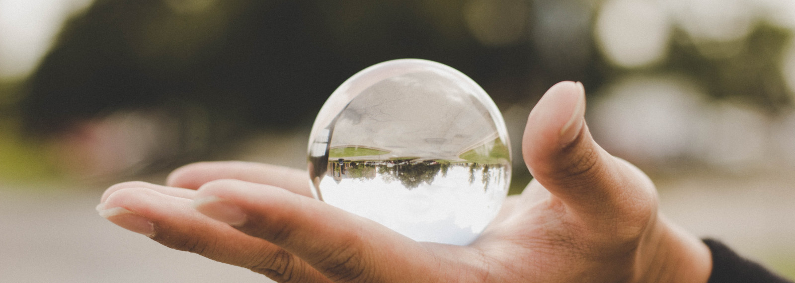 Hand holding a transparent spherical orb