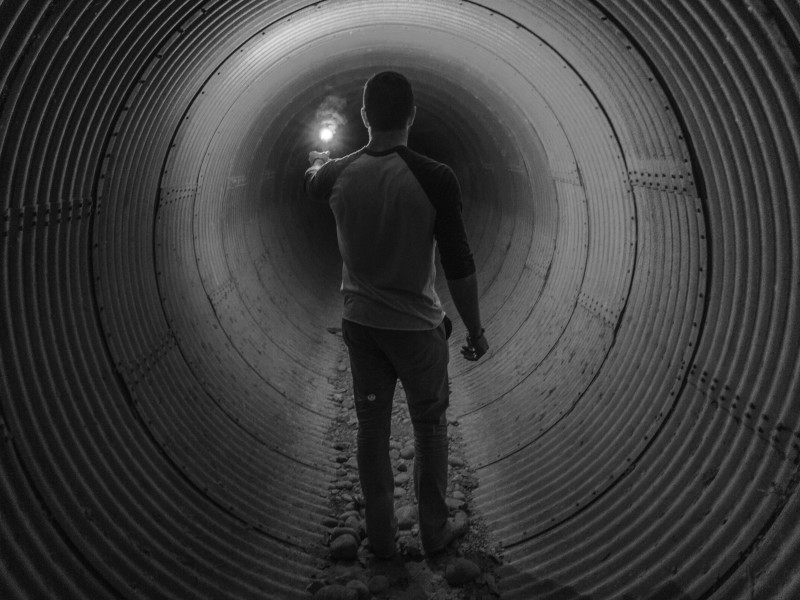 Image of a man walking through a circular tunnel