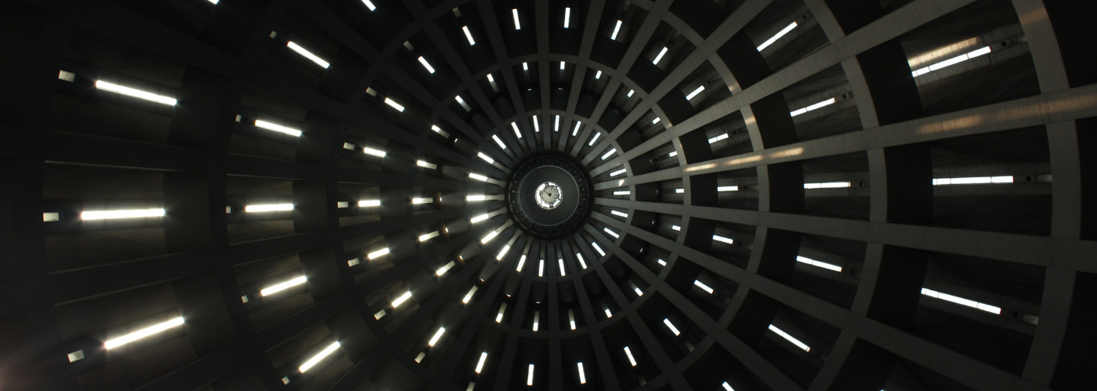 Image looking up into the top of a circular building with narrow windows