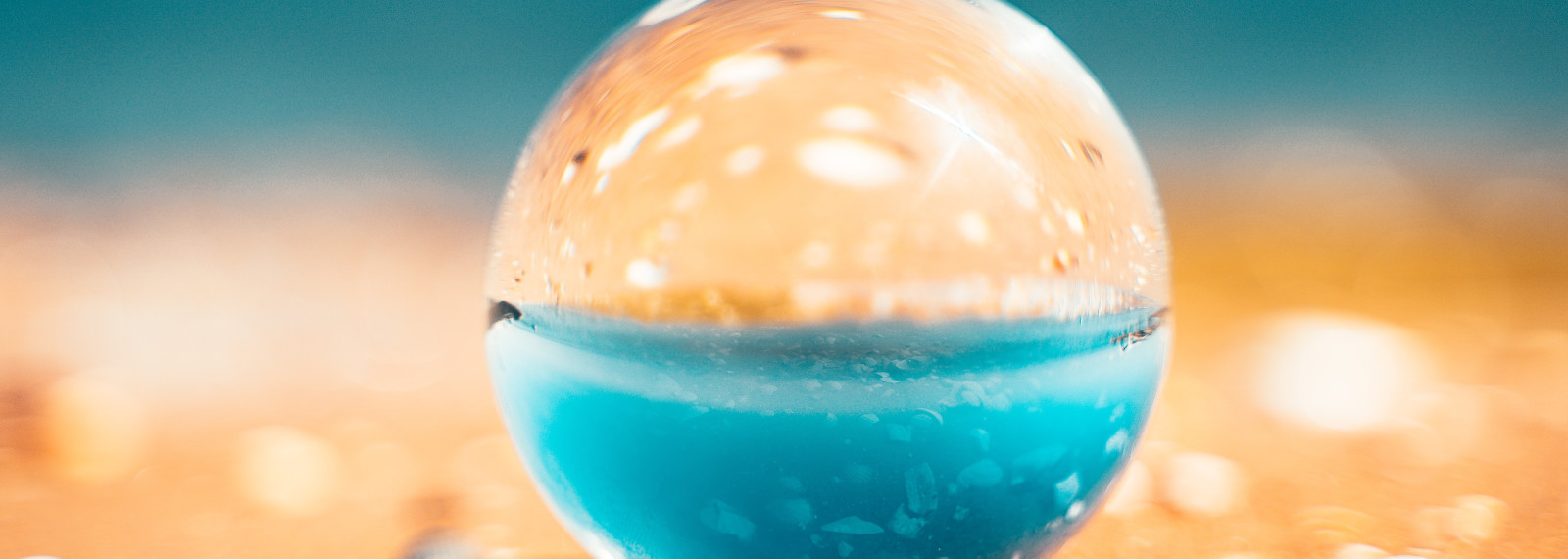 Image of a spherical, transparent object on a beach