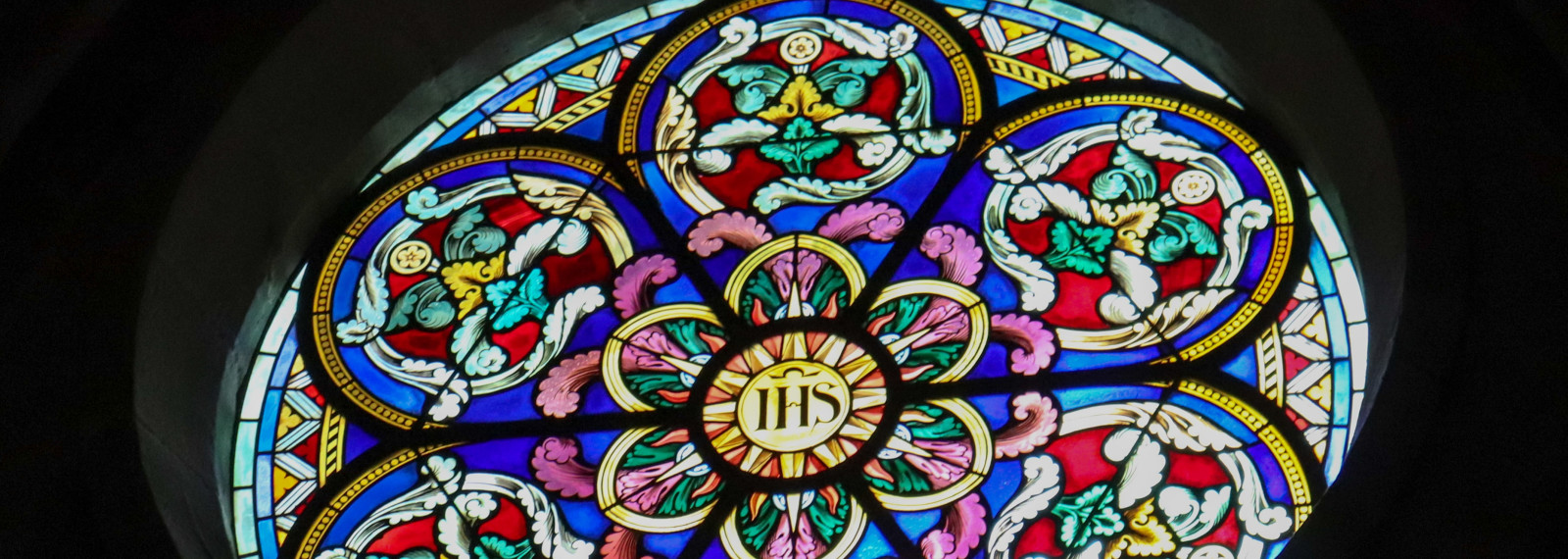 Image looking up at a circular stained glass window