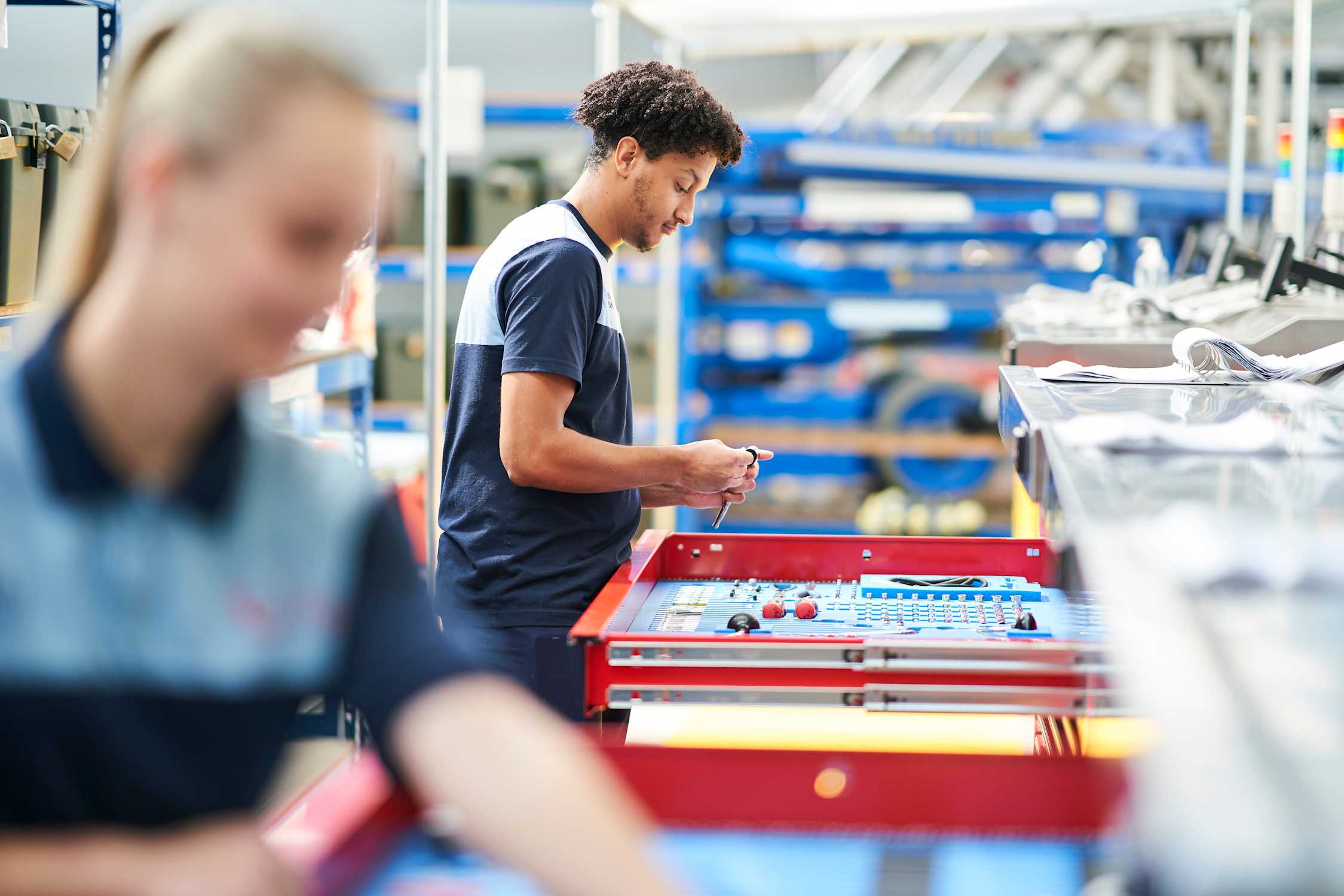 Two young apprentice aircraft engineers working for TUI sort through tools as they work on an aircraft