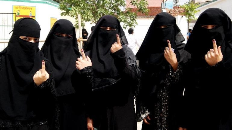 Indian Muslim women displaying inked fingers after voting