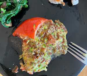 quinoa zucchini, tomato and cheese mixture stuffed into hollowed tomato