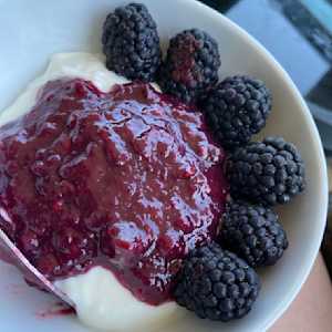 plain greek yogurt topped with mixed berry compote and fresh blackberries