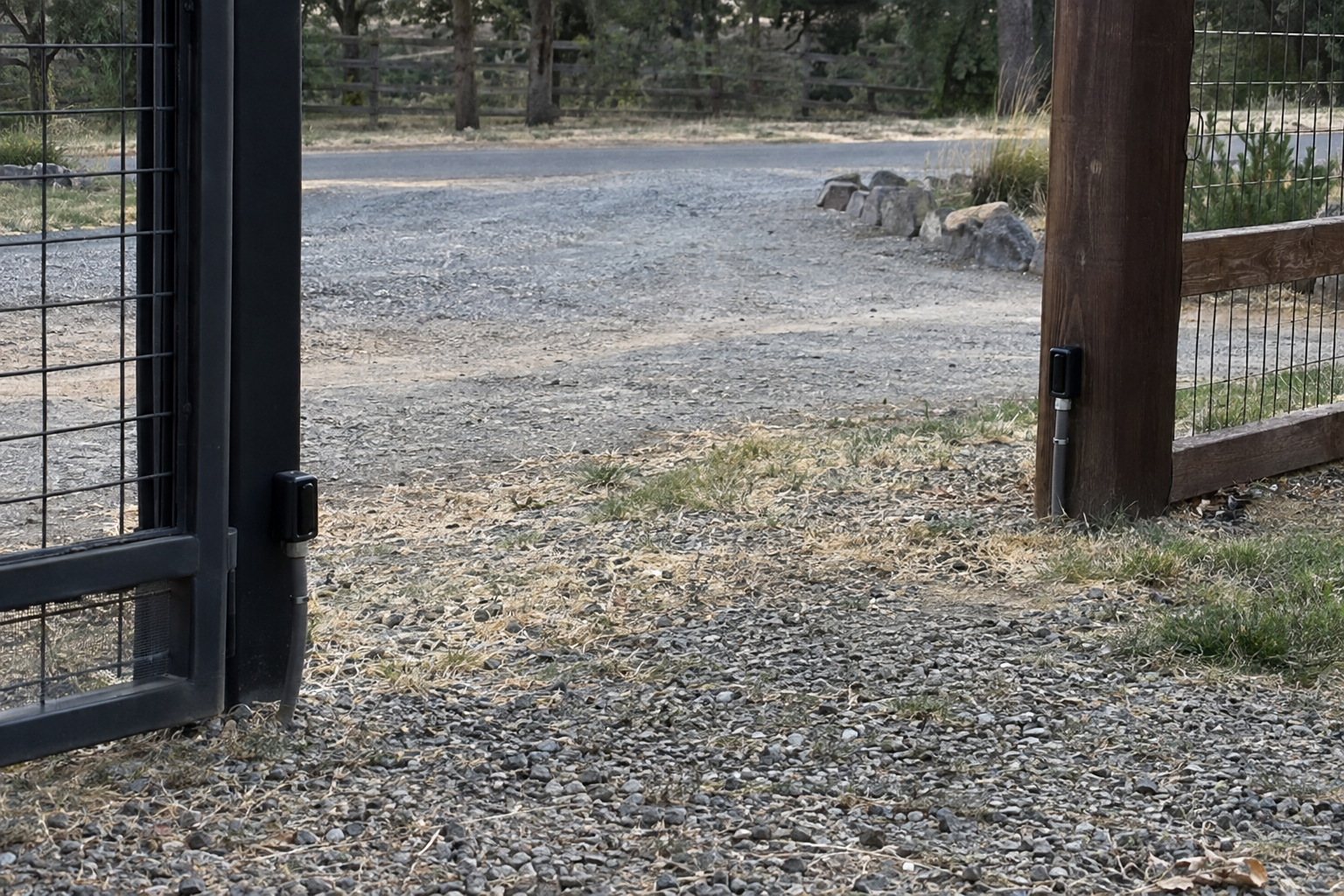 Monitored photo-eye safety sensors mounted across a residential driveway gate opening