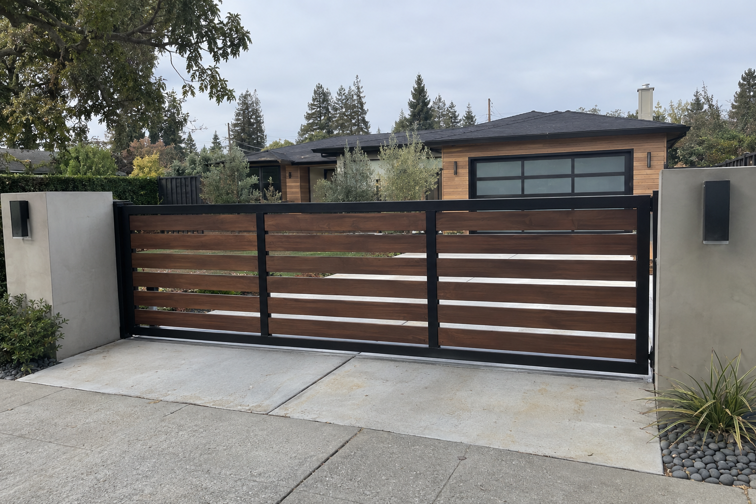 Modern horizontal-slat driveway gate in dark aluminum with wood-look slats at a Sacramento-area home