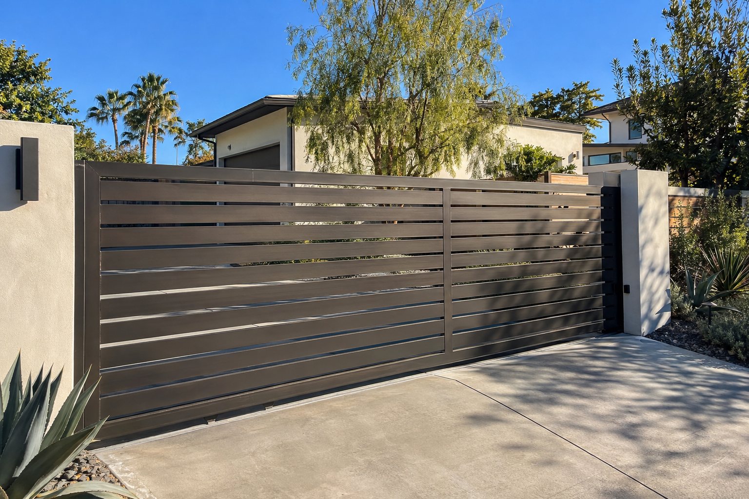 Modern horizontal-slat aluminum driveway gate in dark bronze at a contemporary Sacramento-area home
