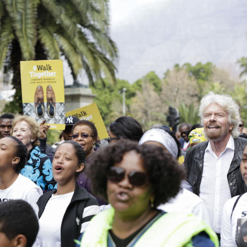 Richard Branson joins a crowd of people on the Walk Together march
