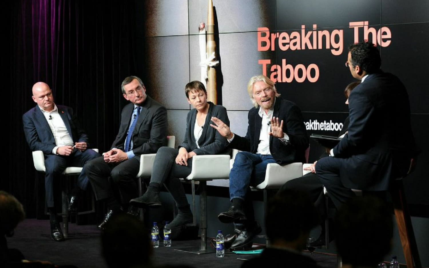 Richard Branson and a panel of sixth other people in front of a sign that reads Breaking The Taboo