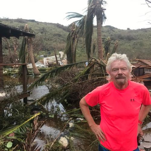 Richard Branson stands in front of damaged buildings caused by Hurricane Irma