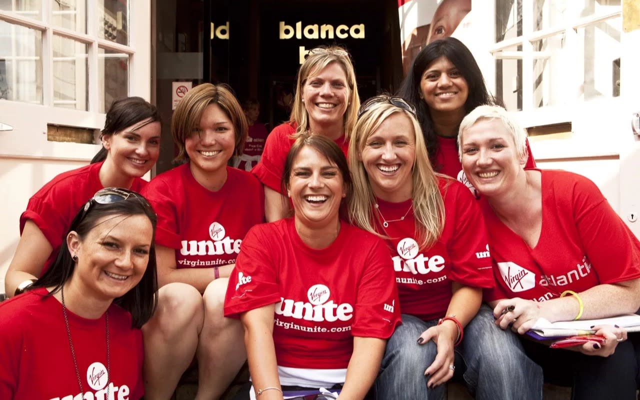 Eight women wearing red Virgin Unite t-shirts