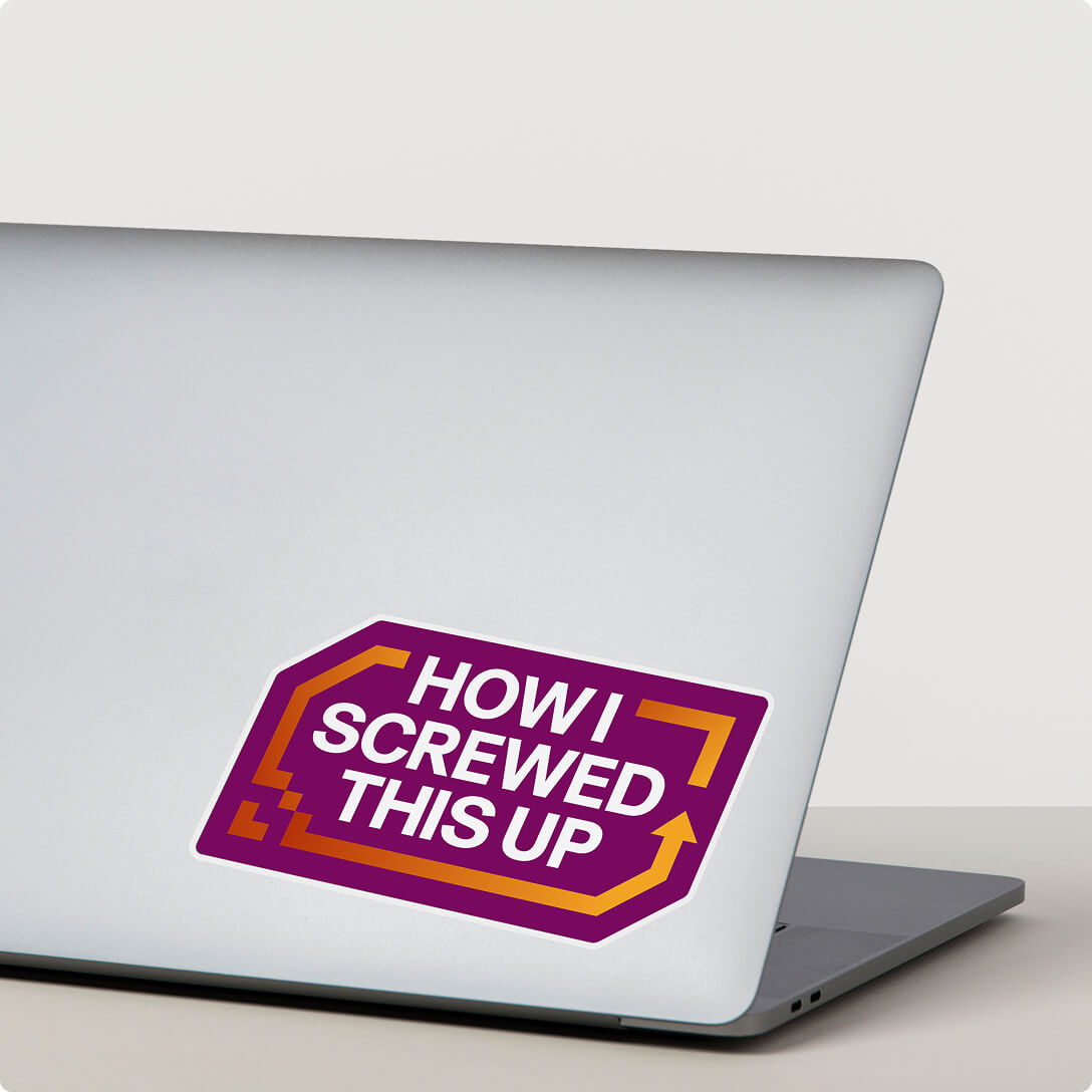 Ordinateur portable argenté avec un autocollant mauve disant « COMMENT J’AI ÉTÉ DANS LE CHAMP » en texte blanc avec des guillemets orange.