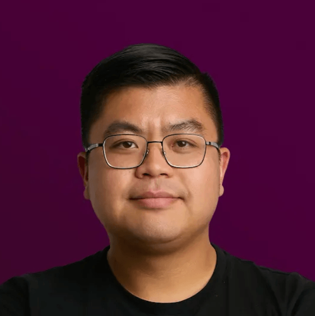 Professional headshot of a person wearing glasses and a black shirt against a deep purple background.