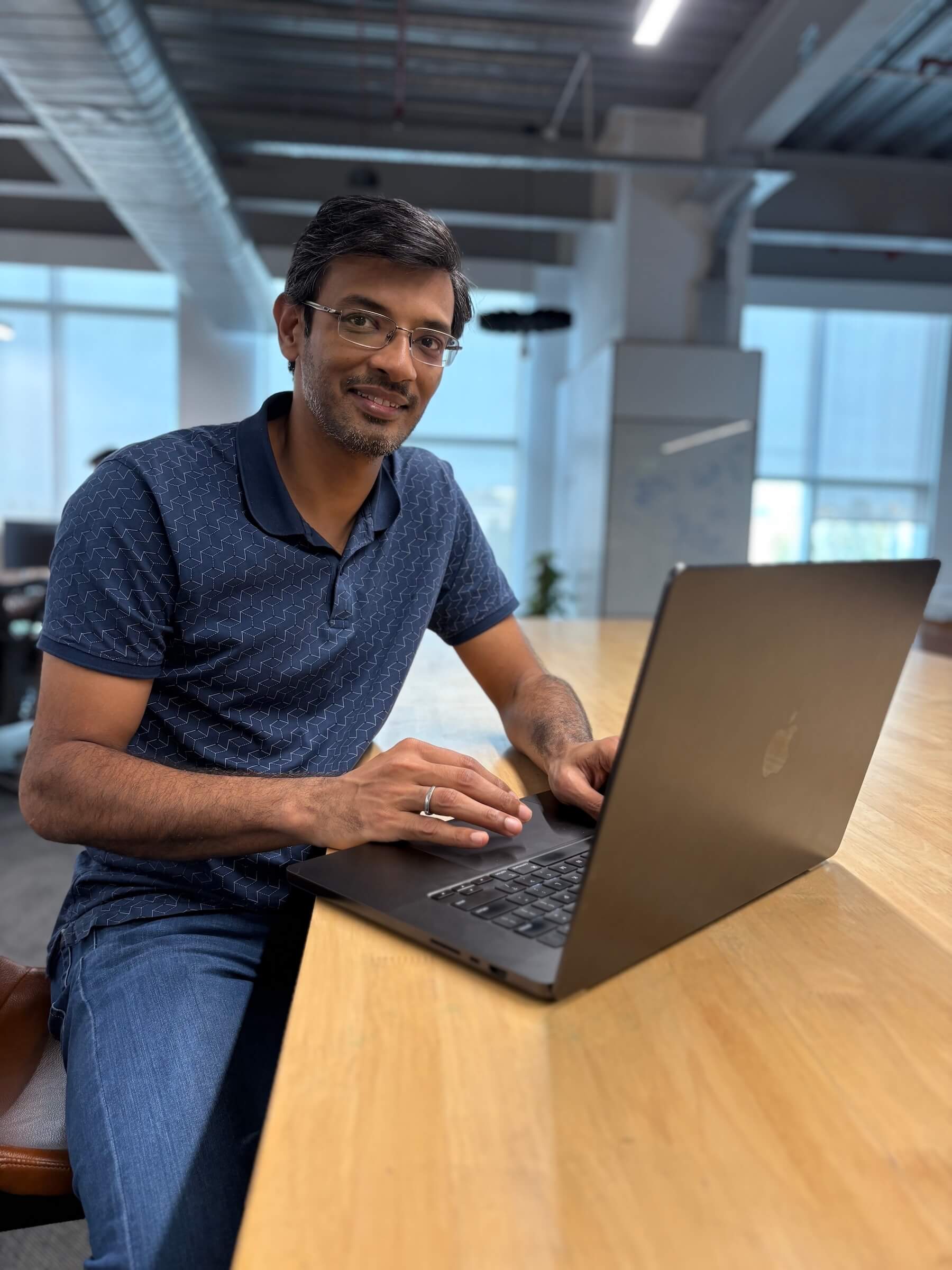 Picture of Ajay Chandra at his laptop. 