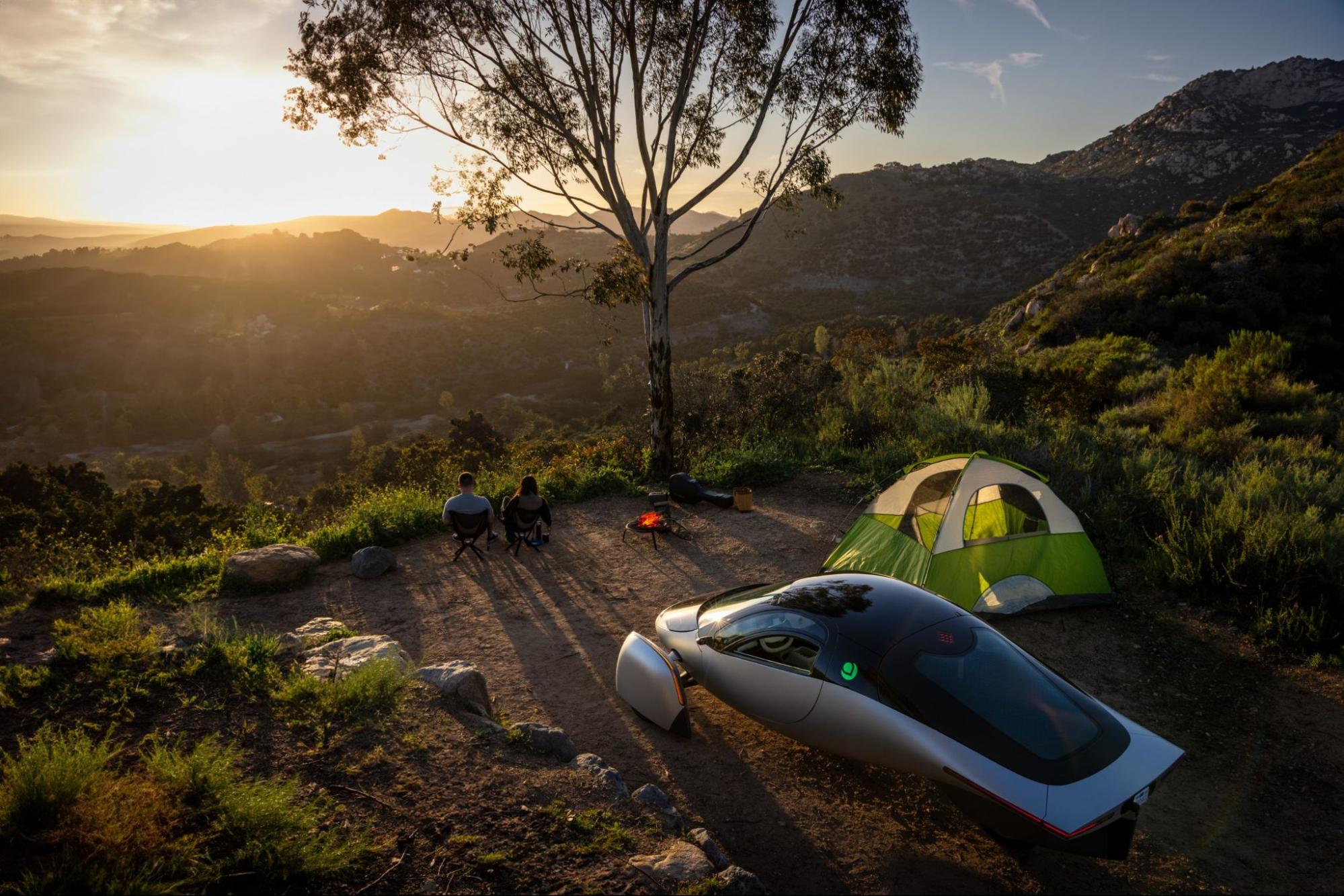Two people camping with a futuristic car and tent. 